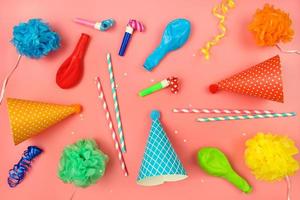 vakantie hoeden, fluitjes, ballonnen Aan roze achtergrond. concept van kinderen verjaardag feest. foto