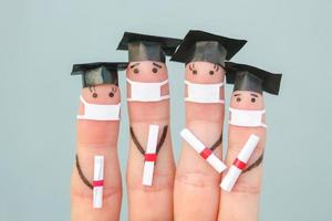vingers kunst van studenten in medisch masker van covid-2019. afgestudeerden Holding hun diploma na diploma uitreiking. foto