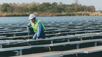 ingenieur inspecteur Holding laptop en werken in zonne- panelen macht fabriek controle fotovoltaïsche cellen en elektriciteit productie. foto