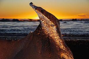 ijs Aan de strand Bij zonsopkomst foto