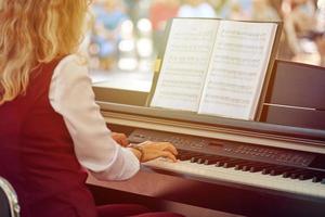 vrouw Toneelstukken elektrisch piano Bij buitenshuis muziek- prestatie, volwassen vrouw pianist met behendig handen foto