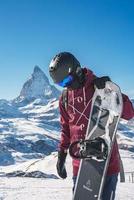 jong snowboarder uitgeven winter vakantie in Zermatt, in de buurt de beroemd matterhorn piek. mannetje poseren in Zwitsers Alpen voor de snowboarden seizoen. foto