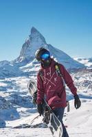 jong snowboarder uitgeven winter vakantie in Zermatt, in de buurt de beroemd matterhorn piek. mannetje poseren in Zwitsers Alpen voor de snowboarden seizoen. foto