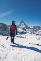 jong snowboarder uitgeven winter vakantie in Zermatt, in de buurt de beroemd matterhorn piek. mannetje poseren in Zwitsers Alpen voor de snowboarden seizoen. foto