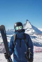 jong skiër genieten van zermatt ski toevlucht. mooi zonnig dag met een skiër omhoog in de bergen. sport- model. foto