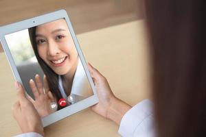 dokter online video conferentie met de geduldig naar toezicht houden op en vragen voor symptomen van de ziekte en geven advies en overleg Aan hoe naar nemen zorg van Gezondheid, telegeneeskunde en telehealth concept. foto