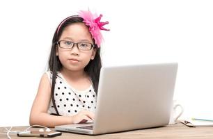 schattig leerling meisje met laptop computer Aan de tafel geïsoleerd foto