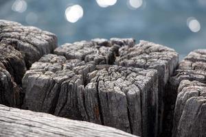 houten structuur van oud hout Aan de strand. houten structuur van de oppervlakte van de pier. houten pier Aan de achtergrond van de zee.close-up van oud verweerd hout foto