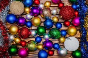 kleurrijk Kerstmis ballen en klatergoud Aan houten tafel achtergrond. detailopname visie van Kerstmis decoratie foto