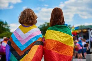 twee Dames met lgbtq regenboog vlaggen Aan trots demonstratie foto