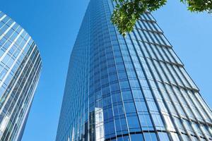 modern stad architectuur, wolkenkrabber glas facade met groen boom foto