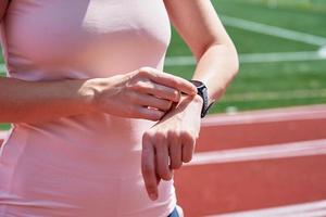 vrouw gebruik geschiktheid slim horloge, controle resultaten na sport opleiding foto