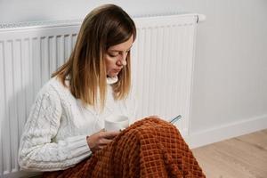 vrouw bevriezing in leven kamer Bij winter seizoen foto