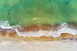 kustlijn met blauw zee golven en zand strand, top visie foto