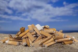 sigaret stompjes liet vallen en links in een stapel Aan een mooi strand foto