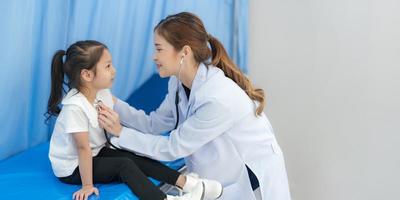 de meisje zit Aan de patiënten bed voor de dokter. foto