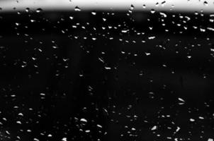 water druppels Aan glas structuur abstract zwart donker achtergrond, selectief focus foto