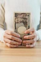 vrouw hand- tellen Japans yen bankbiljet over- tafel achtergrond. duizend yen geld. Japan contant geld, belasting, recessie economie, inflatie, investering, financiën, besparingen, salaris en betaling concepten foto