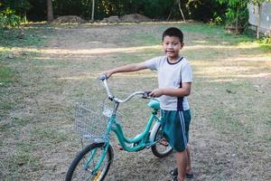 jongen die met een fiets loopt foto