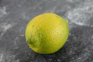 een groene rijpe citroen op een marmeren achtergrond foto