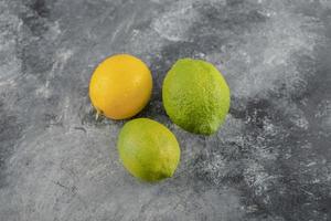 gele en groene citroenen op een marmeren achtergrond foto