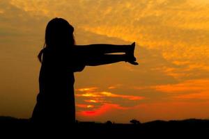 silhouet van vrouw opdrachten Bij zonsondergang geel Aan lucht mooi in zomer foto