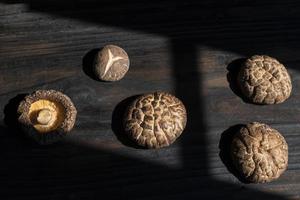 droog shiitake paddestoel Aan donker hout tafel. foto