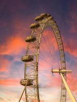 ferris wiel in de amusement park Aan achtergrond van zonsondergang lucht met wolken. laag hoek visie van een groot ferris wiel. foto