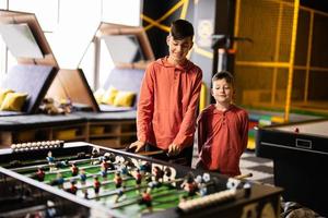 broers spelen tafel Amerikaans voetbal in kinderen Speel centrum. foto