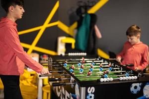 broers spelen tafel Amerikaans voetbal in kinderen Speel centrum. foto