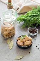 gepekeld champignons - boletus in een kom en in een glas pot Aan de tafel. biologisch vegetarisch voedsel. verticaal visie foto