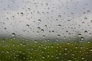 regen druppels Aan venster bril oppervlak. regen druppels geïsoleerd Aan bewolkt achtergrond foto