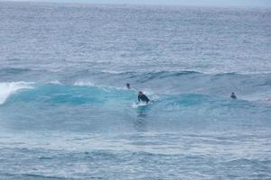 jong atleten beoefenen de water sport van surfing foto