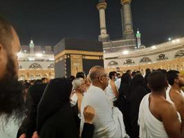 mekka, saudi Arabië, maart 2023 - gedurende de maand van Ramadan, pelgrims van allemaal over- de wereld uitvoeren tawaf in de omgeving van de kabah Bij de masjid al-haram in mekka.. foto