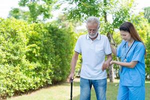 ouderen Mens praten naar artsen en verpleegsters in de ziekenhuis. senior mannetje gelukkig na ontvangen behandeling en zorg en praktijk wandelen van een professioneel dokter. Gezondheid zorg, fysiek therapie, verpleging huis foto