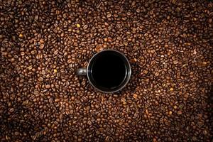 bovenaanzicht van zwarte koffiemok op de achtergrond van koffiebonen foto