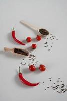 kers tomaten, rood heet Chili peper, geurig zwart peper erwten Aan een wit achtergrond. achtergrond met specerijen. vlak leggen, kopiëren ruimte foto