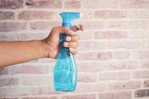 Holding een plastic fles sproeien desinfecteren foto