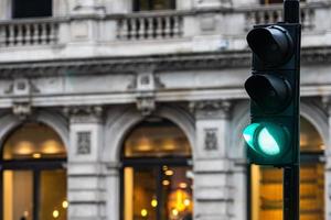 groene verkeerslichten voor auto's op de achtergrond van een vage gebouwen foto