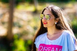openluchtportret van mooie, emotionele, jonge vrouw in zonnebril