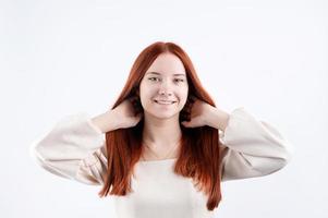 portret van een jong mooi vrouw aanraken haar rood haar- Aan wit achtergrond, kopiëren ruimte foto