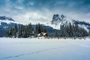 smaragd meer met houten lodge gloeiend in besneeuwd pijnboom Woud en rotsachtig bergen Aan winter Bij yoho nationaal park foto