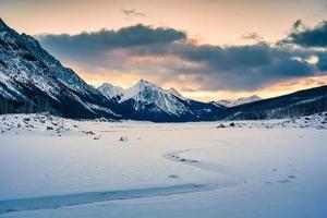 zonsopkomst over- geneeskunde meer met rotsachtig bergen en bevroren meer in Jasper nationaal park foto