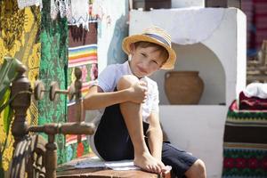 Wit-Russisch of oekraïens jongen in een rietje hoed tegen de achtergrond van de fornuis. land kind. foto