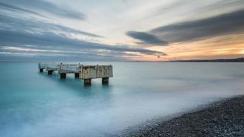 lange blootstelling van een strand tijdens zonsondergang in Nice, Frankrijk foto