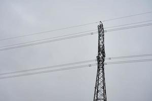 hoogspanningsdraadtoren tegen een grijze bewolkte hemel foto