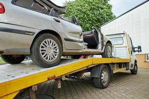 crashte auto bezig met laden in slepen vrachtauto na verkeer ongeluk Aan weg foto