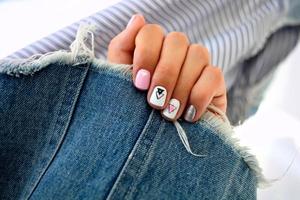 vrouw handen met een mooi manicure Aan een jeans achtergrond. foto