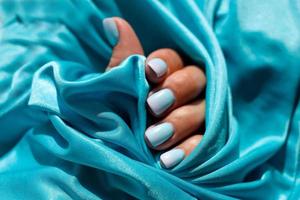vrouw handen met een mooi manicure Aan een blauw achtergrond. foto