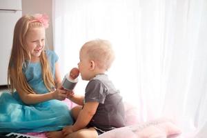 zus geeft broer een microfoon naar zingen. karaoke Bij huis foto